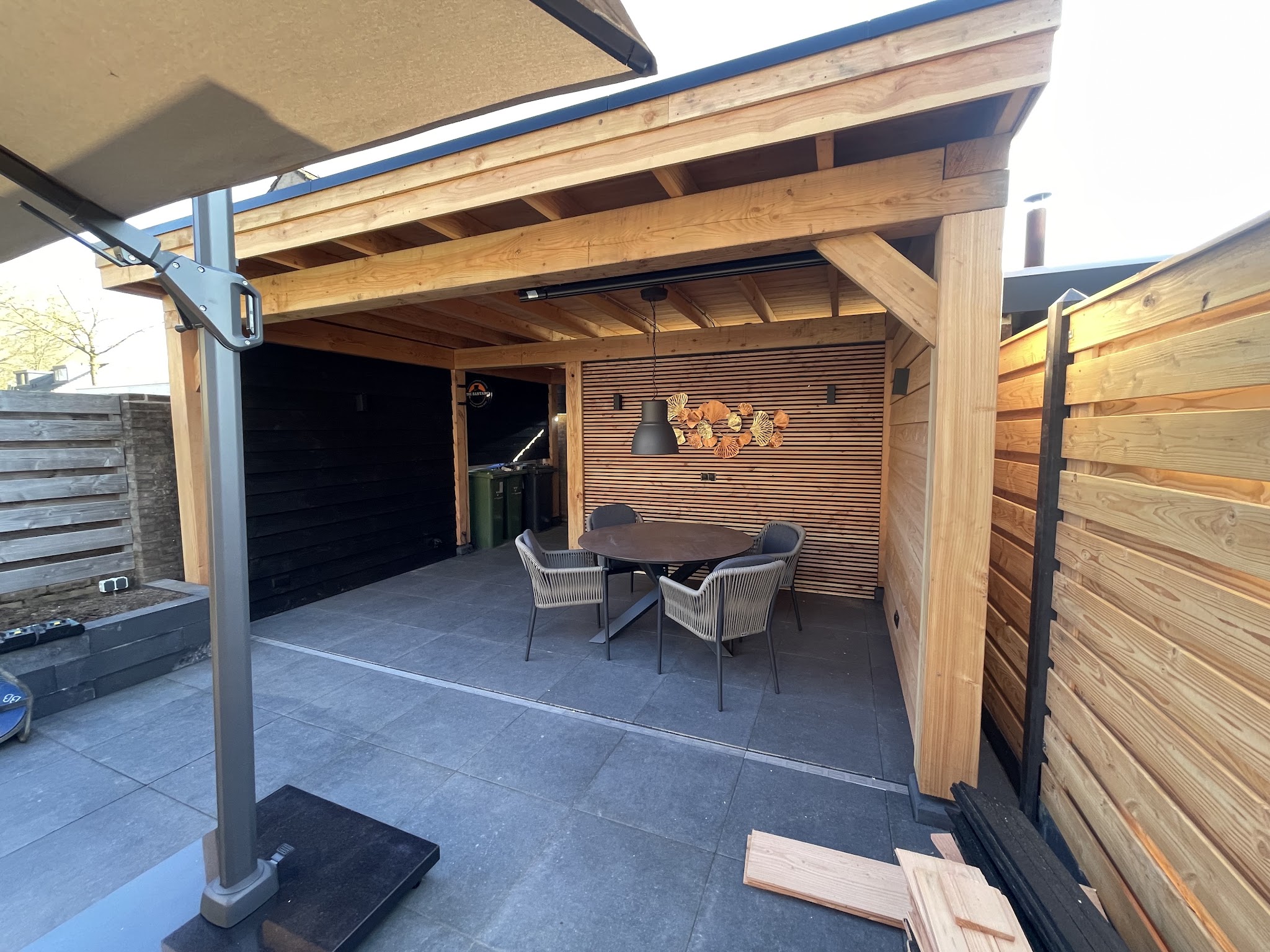 Nieuwe houten overkapping met zitgroep in een achtertuin