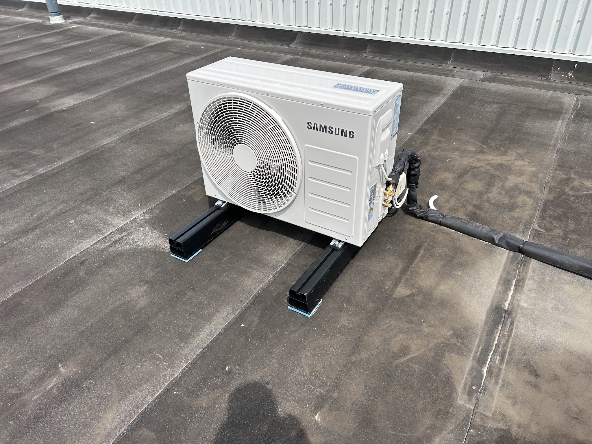 Samsung airco-buitenunit op dakvoeten op een plat dak