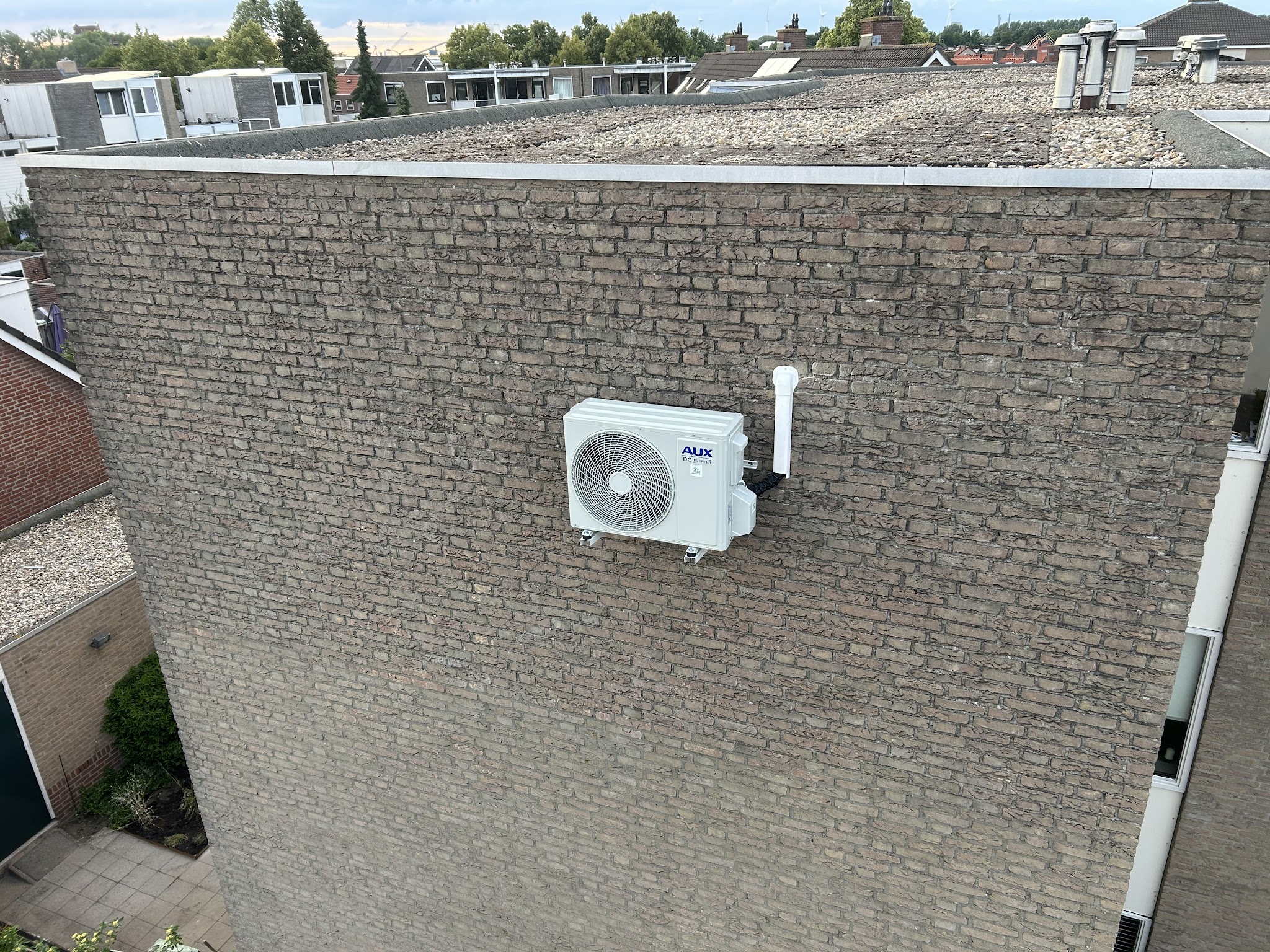 Airco-buitenunit gemonteerd aan een bakstenen gevel
