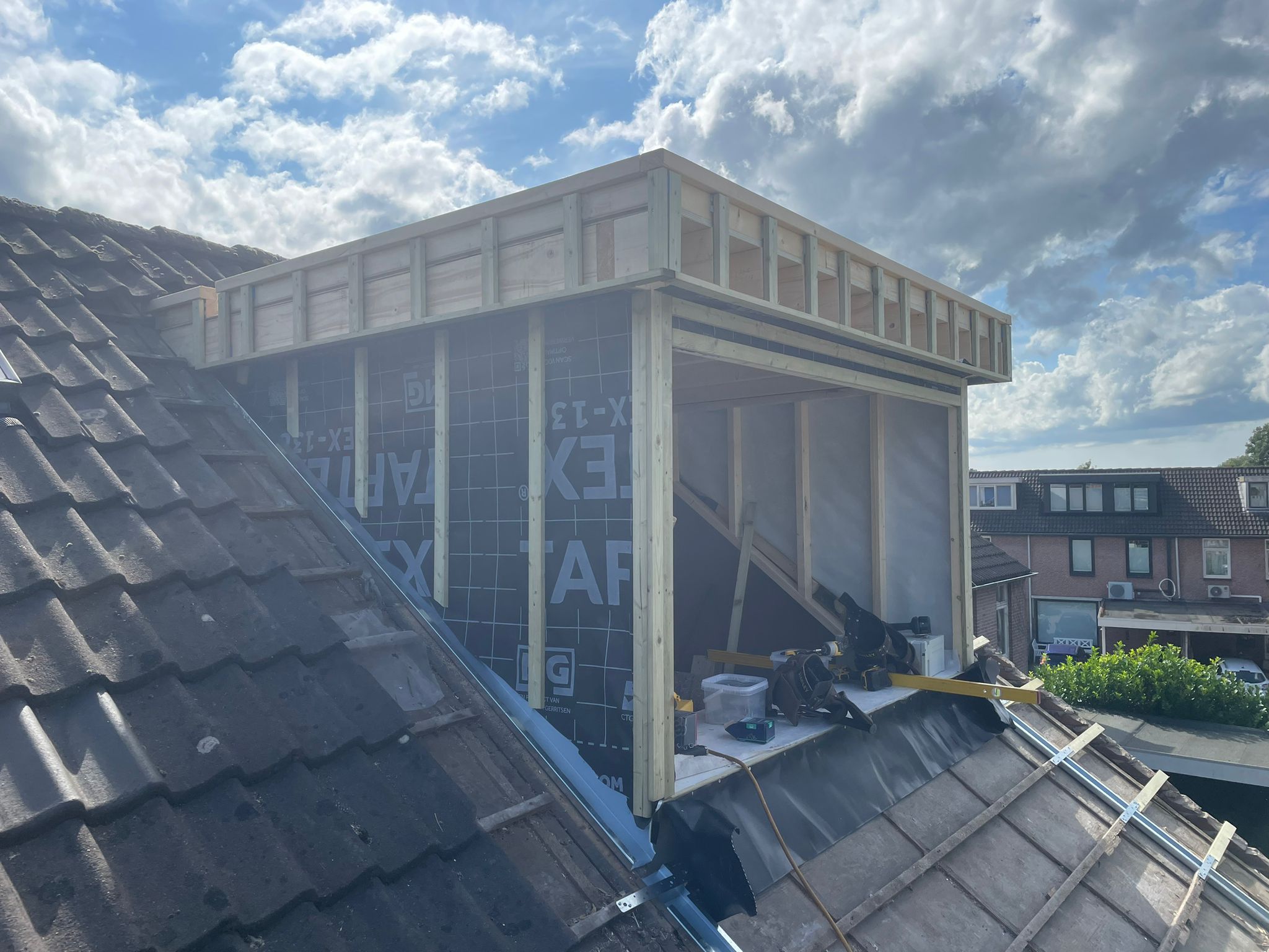 Dakkapel in aanbouw met houten frame op een pannendak