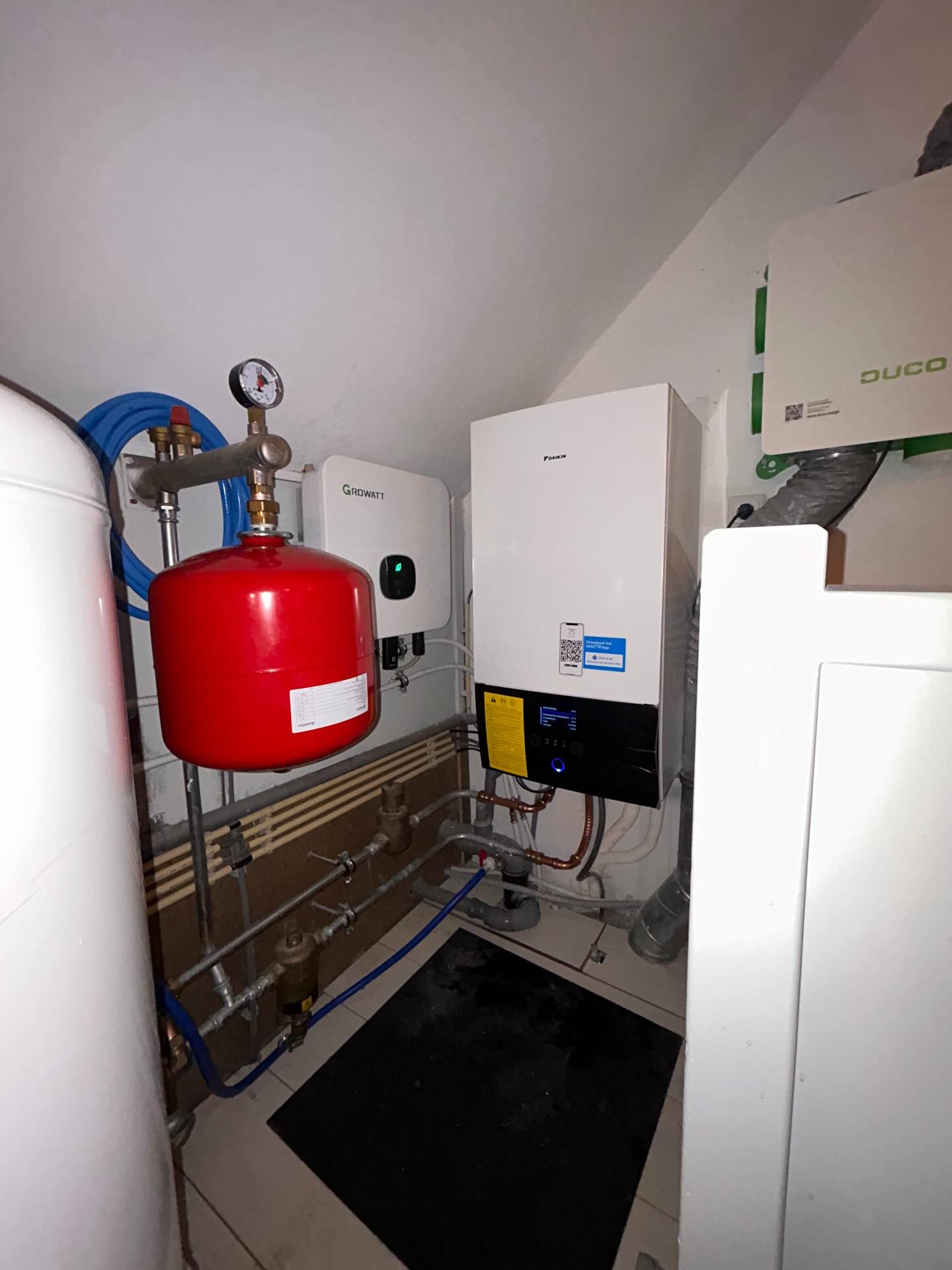 Nieuw geplaatste Daikin warmtepomp met rood expansievat en buffervat