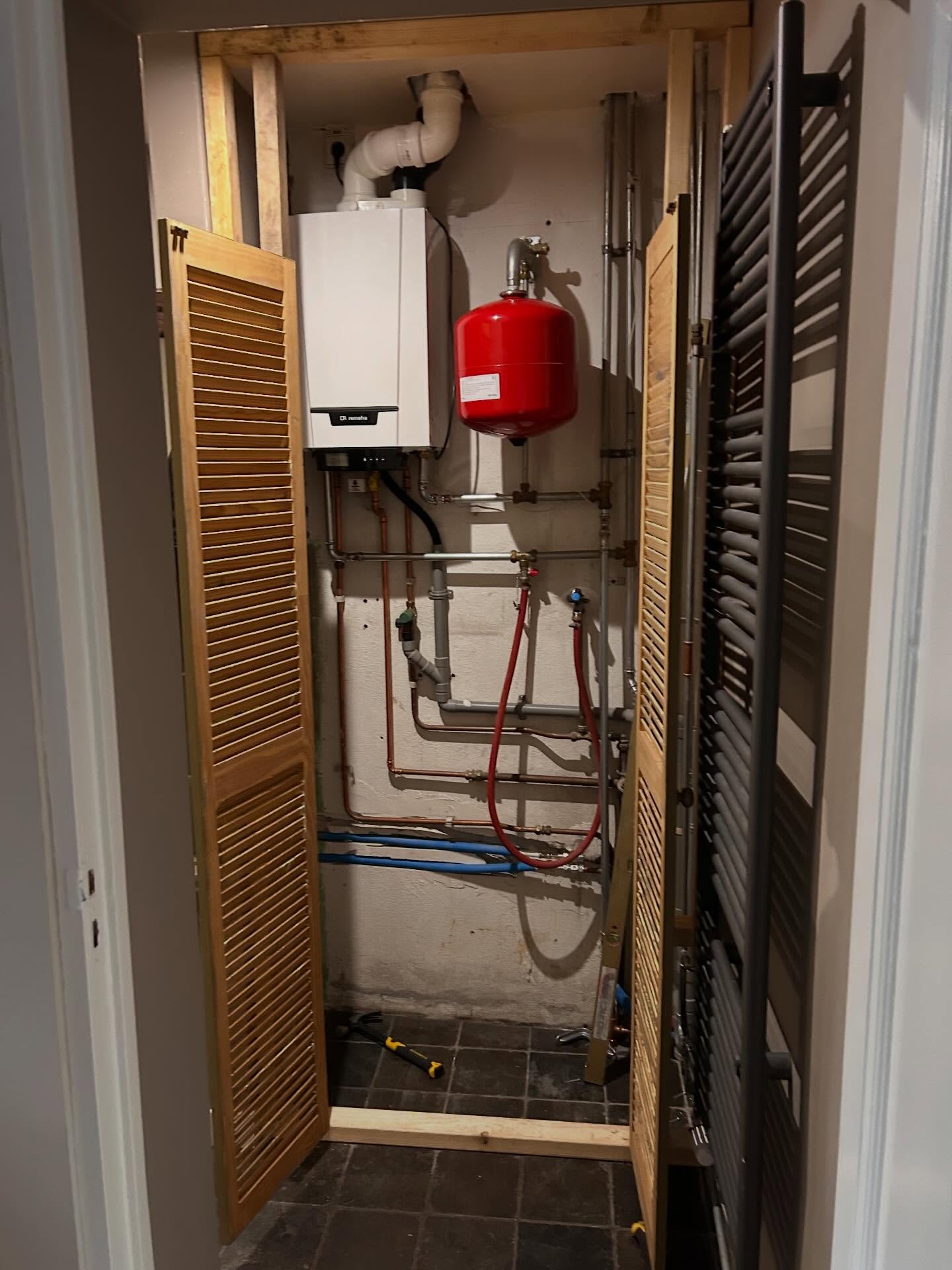 Cv-ketel weggewerkt in een kast met houten lamellendeuren